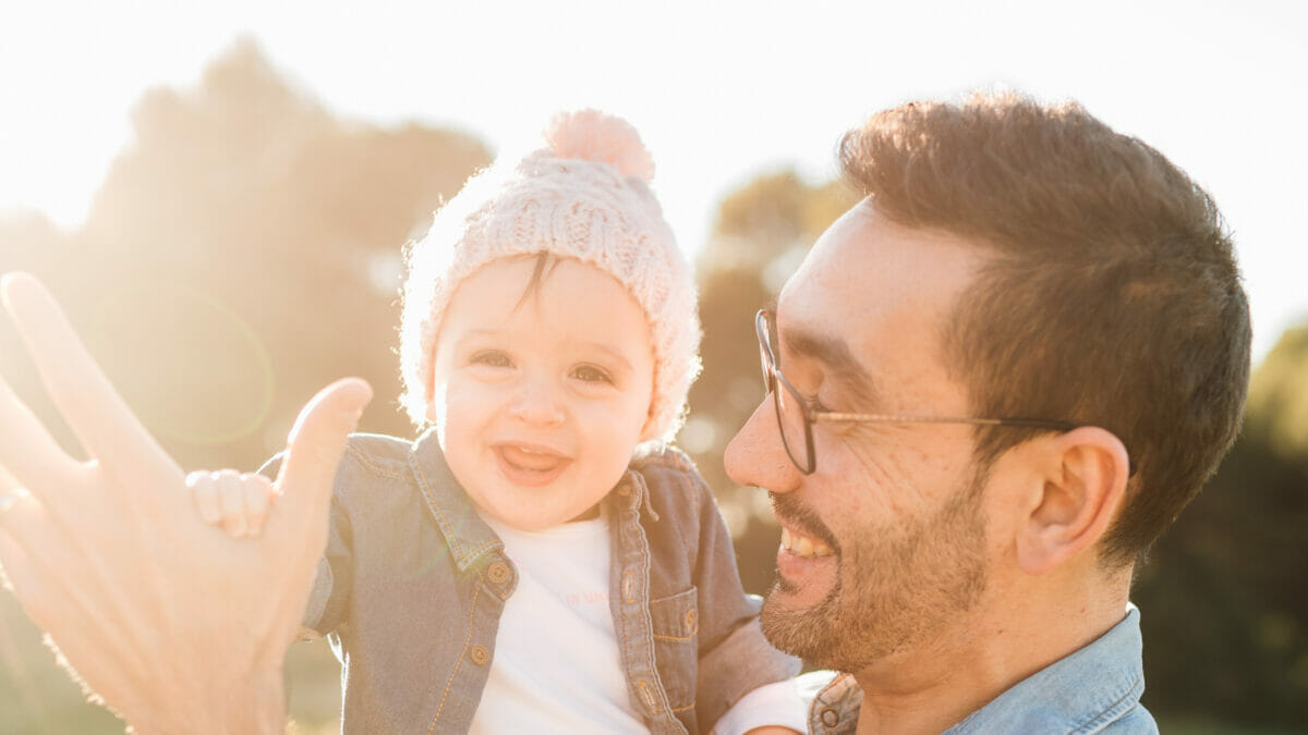 father and son happily smiling under the sun outdoor.