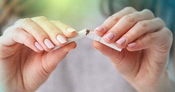 a women Breaking a Cigarette in Half