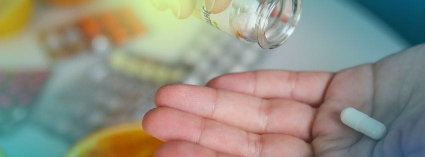 a ahnd holding pills capsule