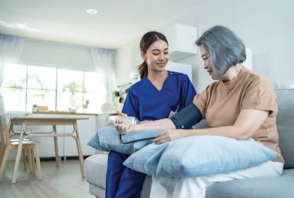 nurse is measuring blood pressure for a woman